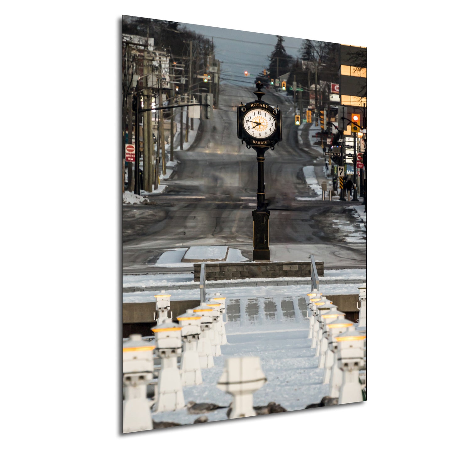 a clock on a pole in the middle of a street