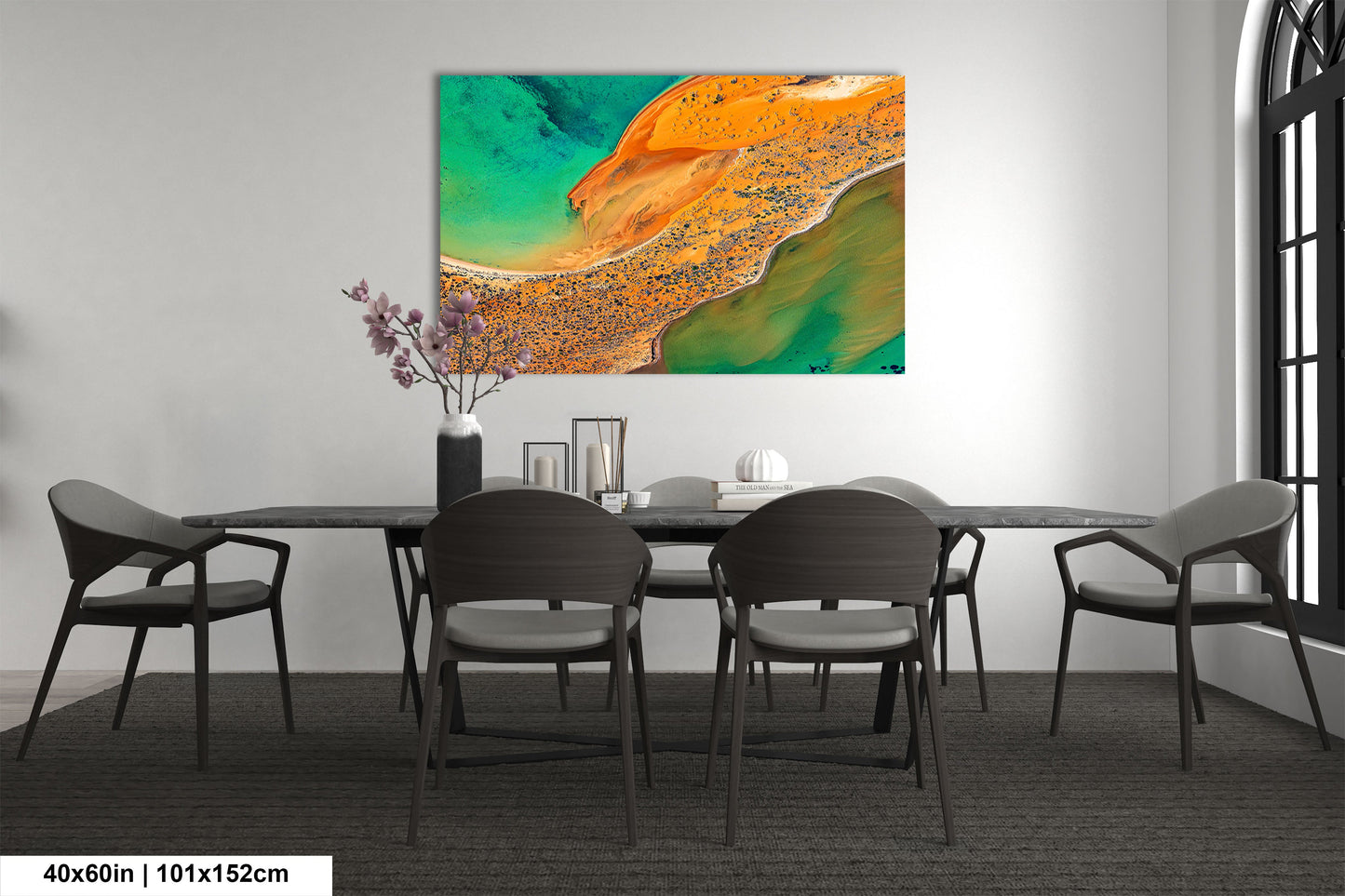a dining room table with chairs and a painting on the wall