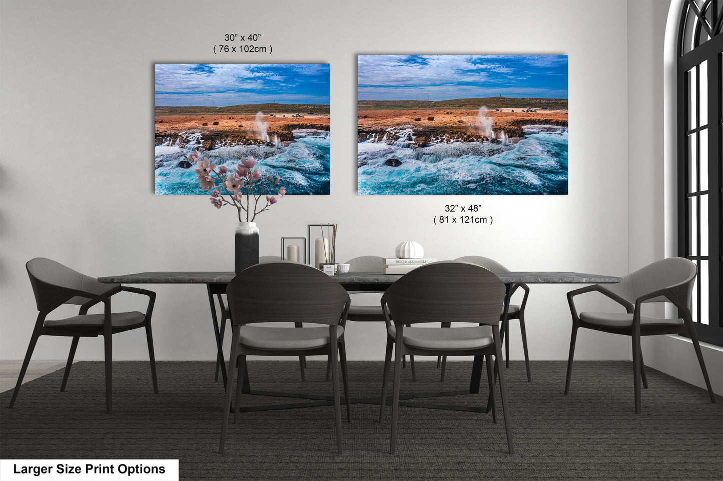 a dining room table with four chairs and two pictures on the wall