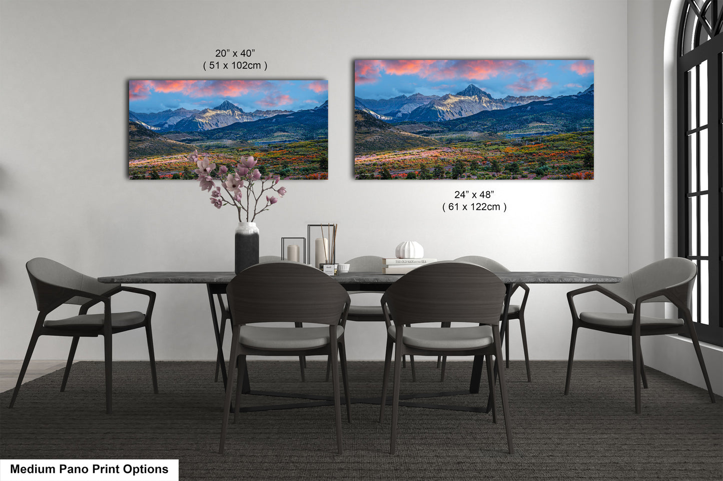 a dining room table with four chairs and a vase of flowers