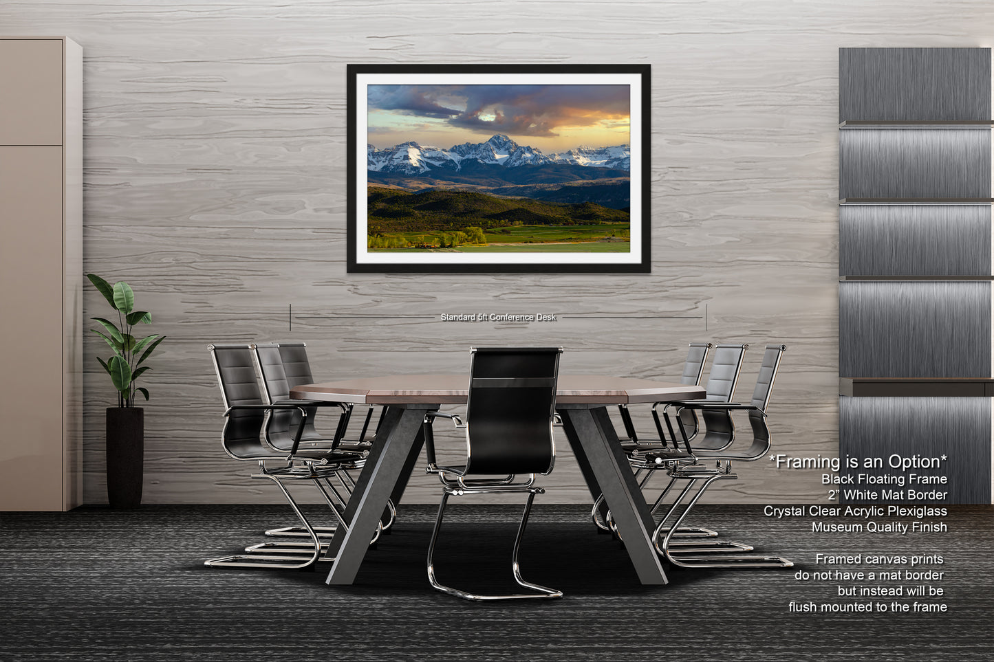 a modern office space with a large framed landscape painting hanging on the wall above a wooden table surrounded by black chairs.
