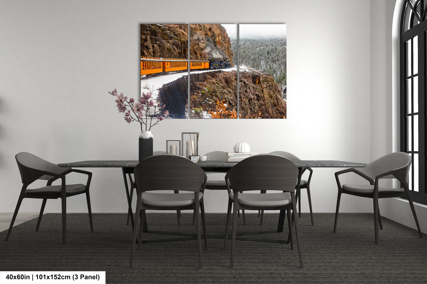 a dining room table with chairs and a painting on the wall