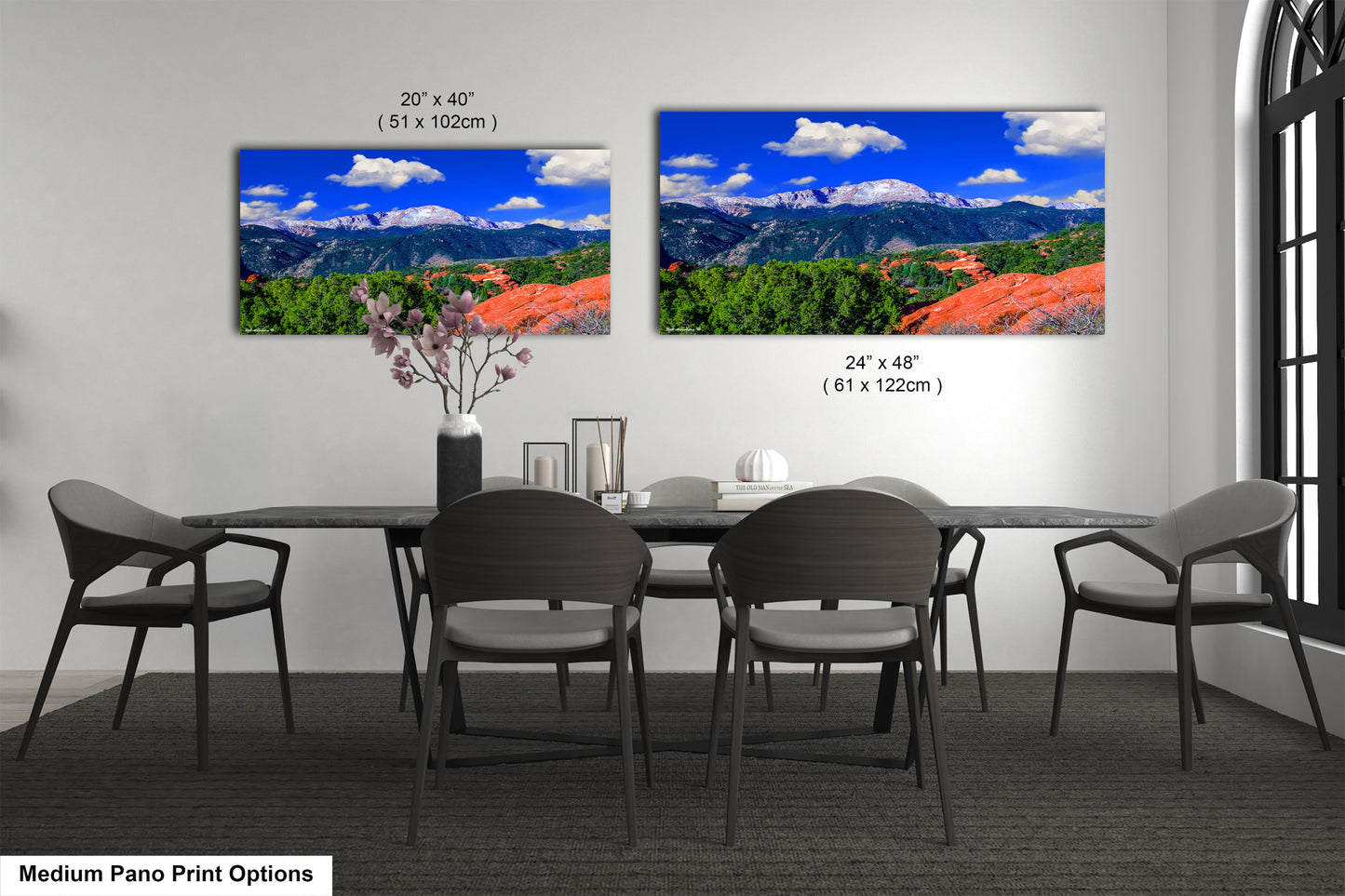 a dining room table with four chairs and two pictures on the wall