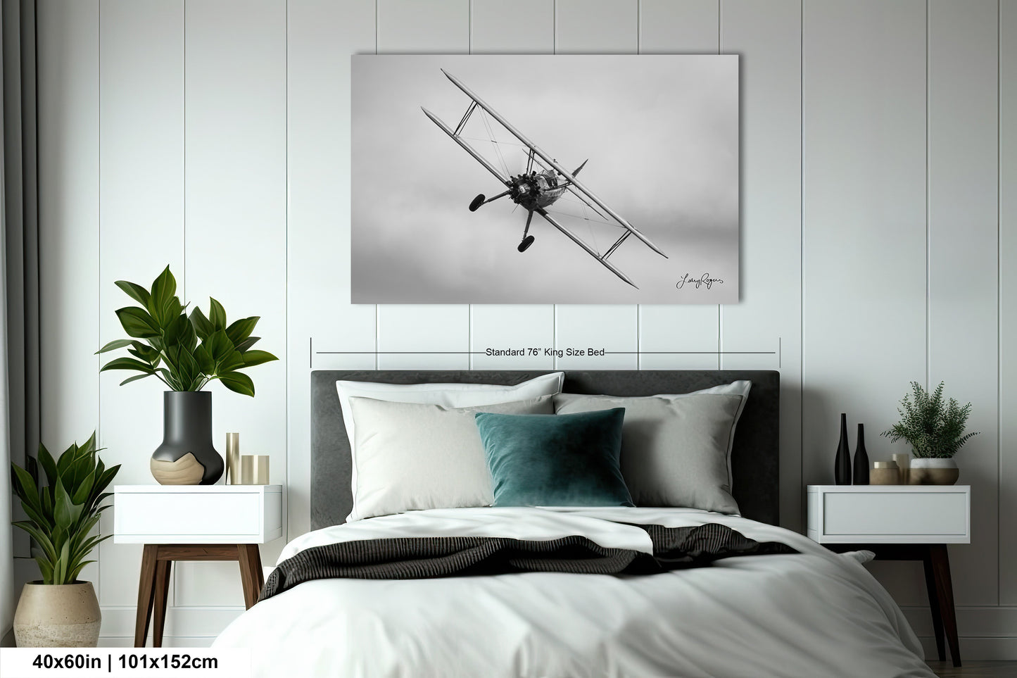 a black and white photo of an airplane on a wall above a bed