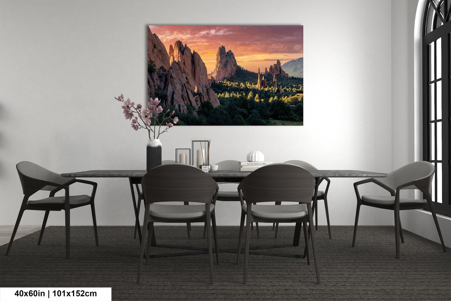 a dining room table with chairs and a painting on the wall