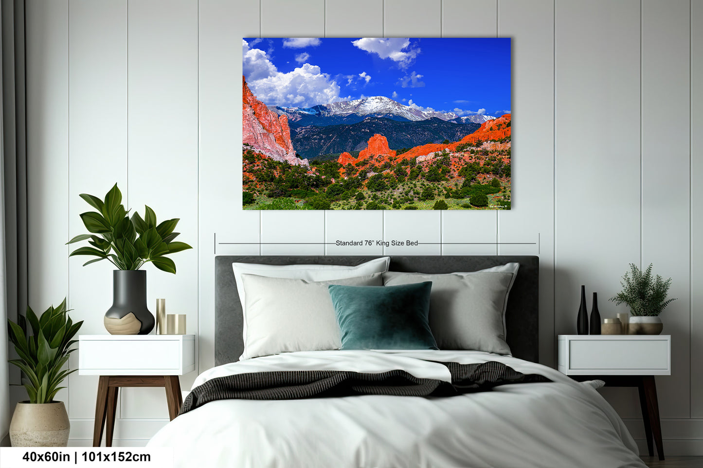 a bed in a room with a large picture on the wall