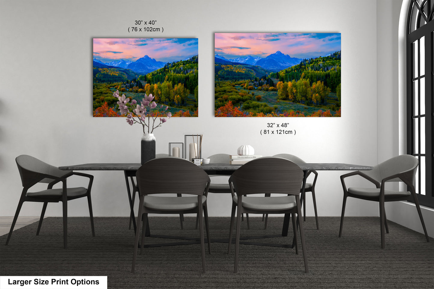 a dining room table with four chairs and a painting on the wall