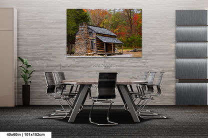 a dining room table with chairs and a painting of a log cabin