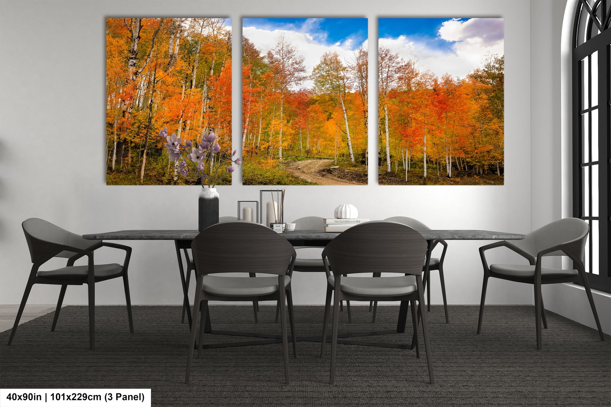 a dining room table with four chairs and a painting on the wall