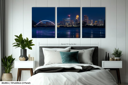 a bedroom with a bed and a night view of a city