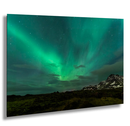 a green and blue sky with a mountain in the background