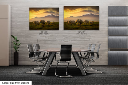 a dining room table with chairs and two pictures of elephants on the wall