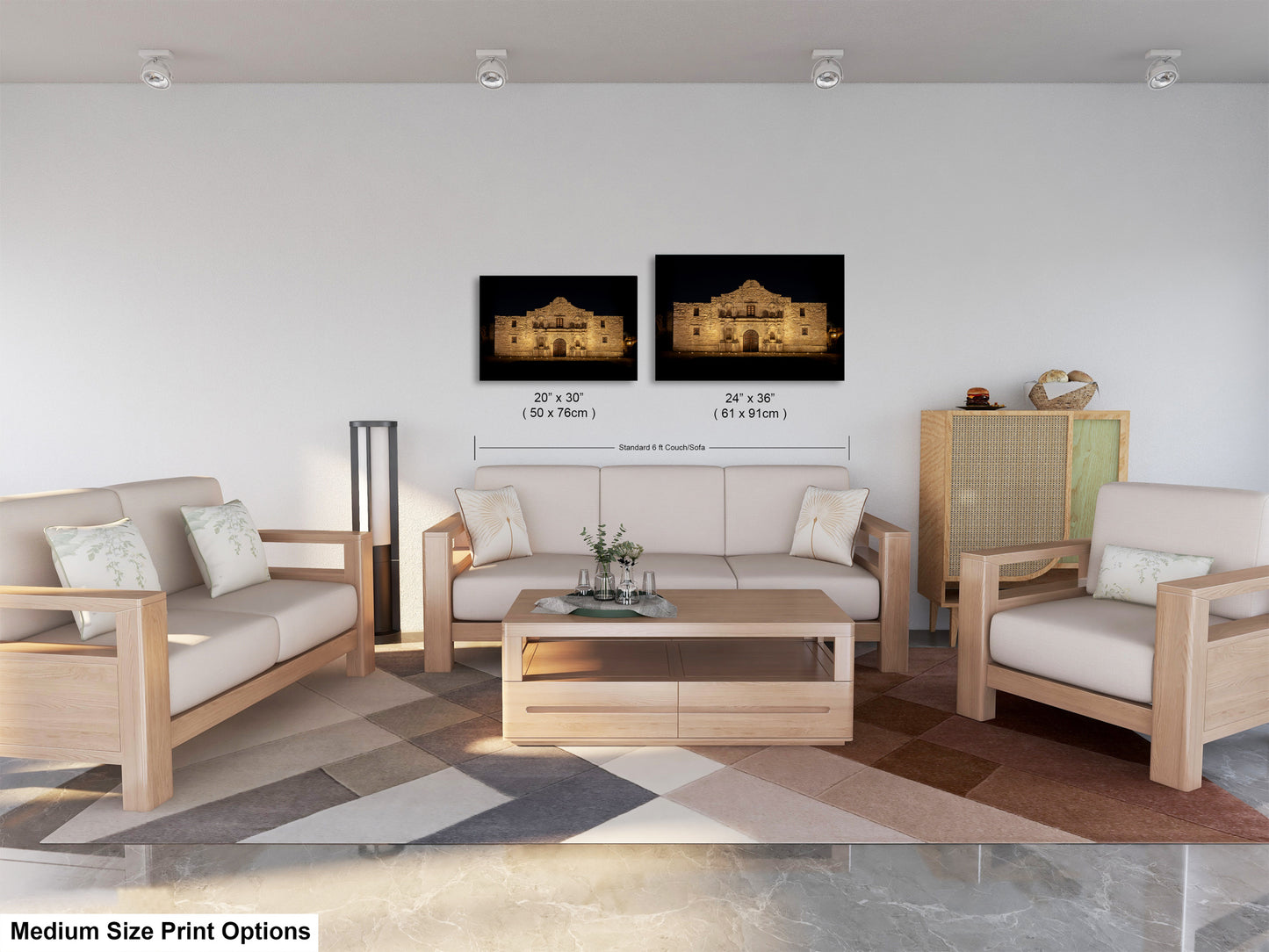 a modern living room with a white sofa, two chairs, and a coffee table. There are two framed pictures of a building on the wall, and the room has a geometric patterned rug on the floor.