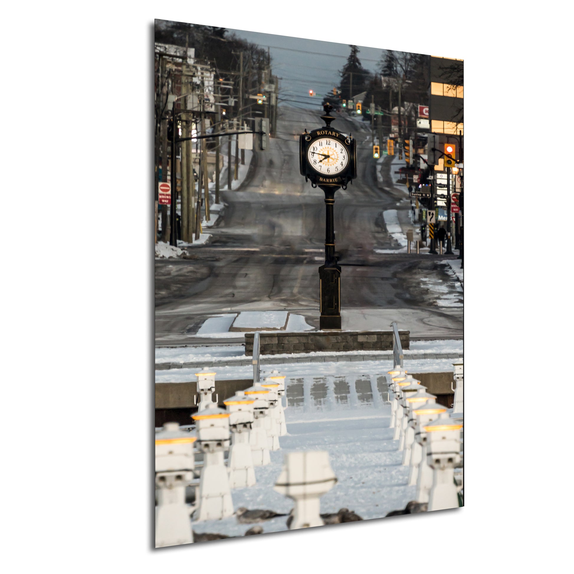 a clock on a pole in the middle of a street