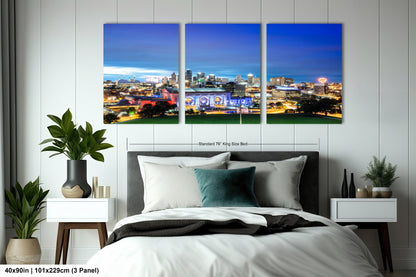 a bedroom with a large bed and three paintings on the wall