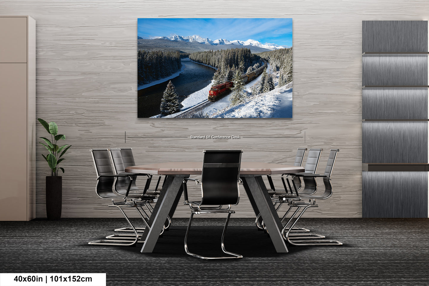 a modern office setting with a large, high-quality photograph of a train traveling through a snowy mountain landscape displayed on the wall above a wooden table surrounded by chairs.