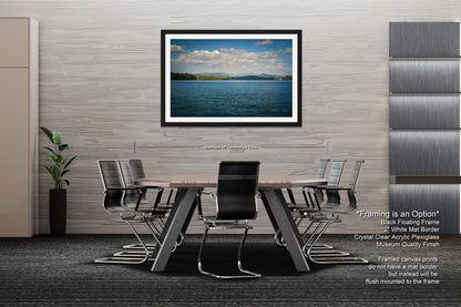 a modern office space with a large framed landscape photograph hanging on the wall above a wooden conference table surrounded by black chairs.