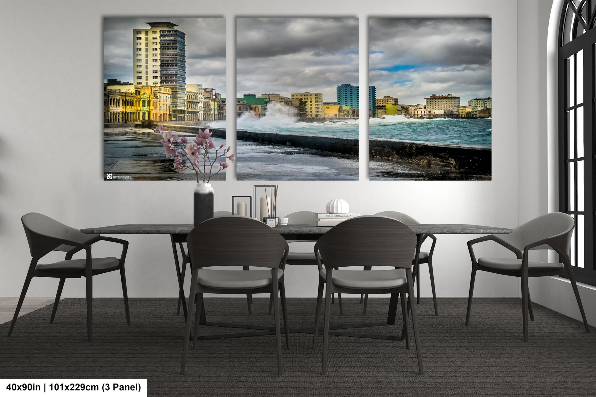 a dining room table with four chairs and a painting on the wall