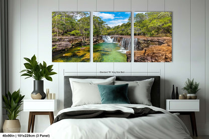 a bedroom with a bed and two paintings on the wall