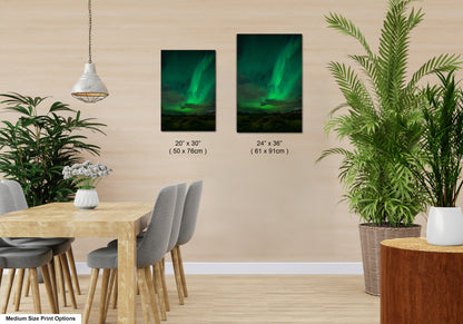 a modern dining room with a wooden table and chairs, a potted plant, and two framed pictures of the northern lights, or aurora borealis, displayed on the wall.