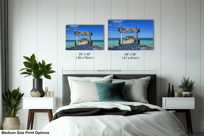 a bed room with a neatly made bed and two pictures on the wall