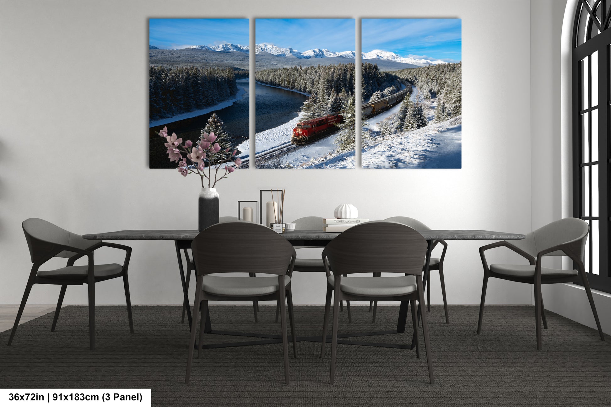 A modern dining room with a large, three-panel landscape painting depicting a snowy mountain scene with a train passing through the valley.