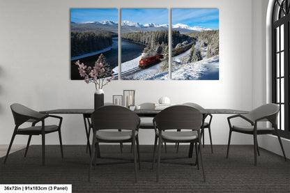 A modern dining room with a large, three-panel landscape painting depicting a snowy mountain scene with a train passing through the valley.