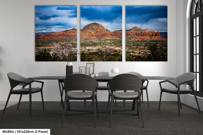 a dining room table with four chairs and three pictures on the wall