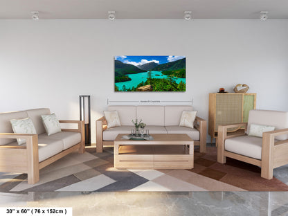 a modern living room with a large, colorful landscape painting hanging on the wall. The room is furnished with a sofa, two chairs, and a coffee table. The painting depicts a scenic view of a lake surrounded by mountains, creating a serene and inviting atmosphere.