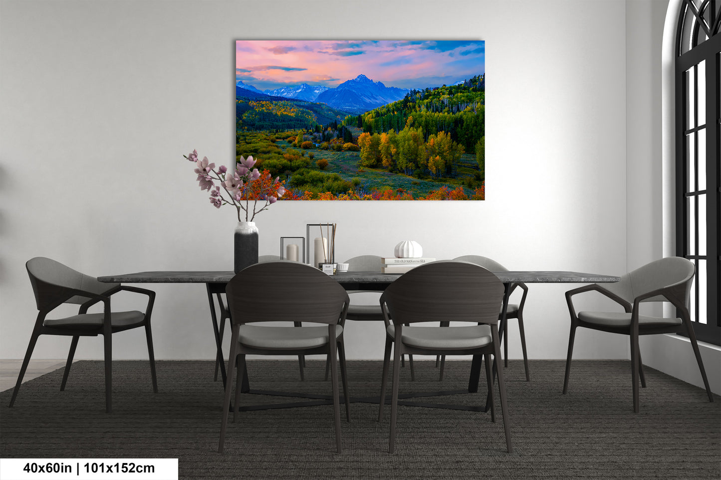a dining room with a table and chairs and a painting on the wall
