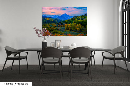 a dining room with a table and chairs and a painting on the wall