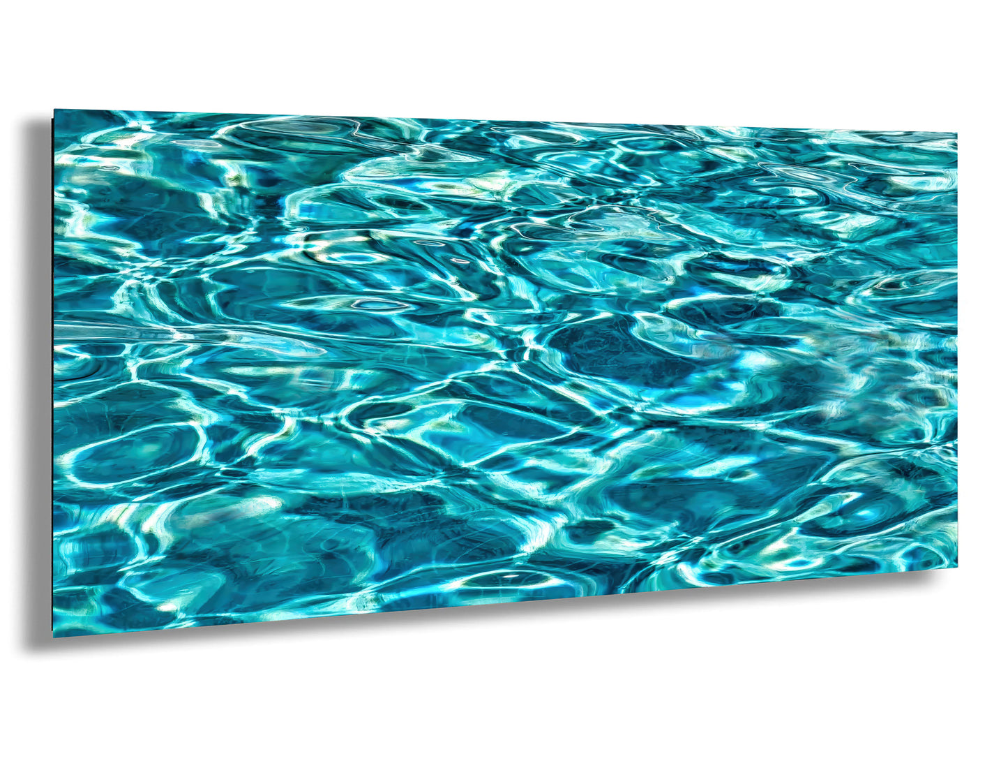 a close-up view of a body of water, possibly a pool or a lake, with its surface rippling and reflecting the light in a beautiful, turquoise-colored pattern.