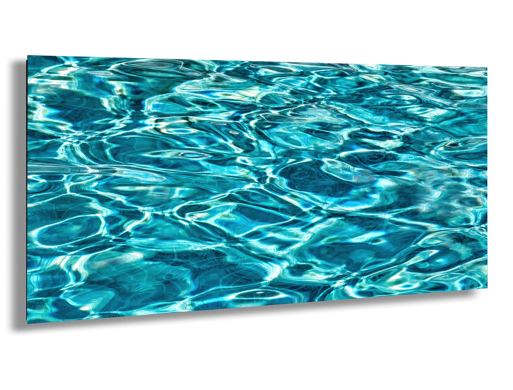 a close-up view of a body of water, possibly a pool or a lake, with its surface rippling and reflecting the light in a beautiful, turquoise-colored pattern.