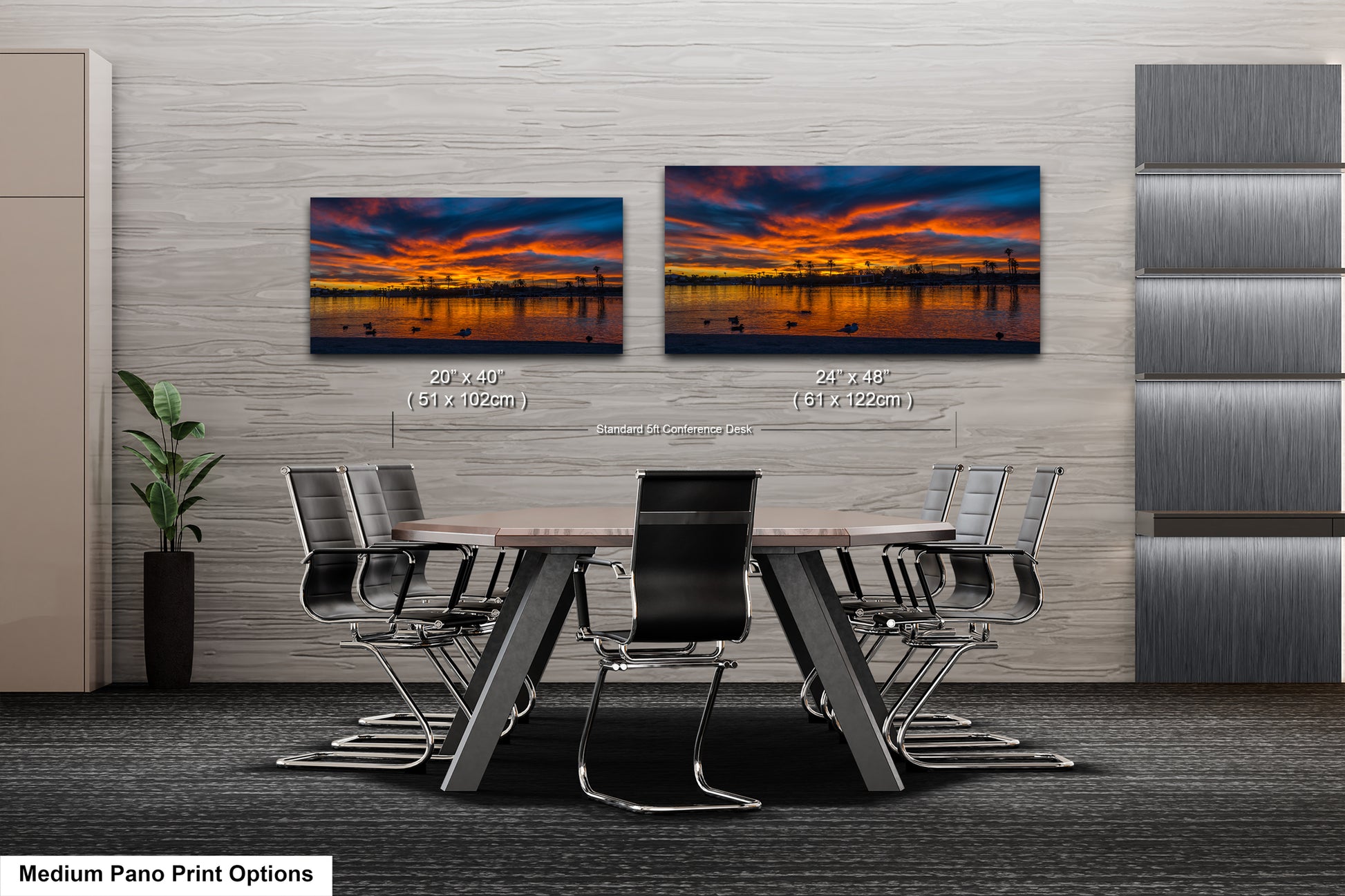a modern office space with a large wall-mounted painting depicting a sunset over a city skyline. The painting is framed in a standard size of 24x48 inches and is displayed in two different positions on the wall. The office space includes a large conference table surrounded by chairs, creating a professional and comfortable environment for meetings and discussions.