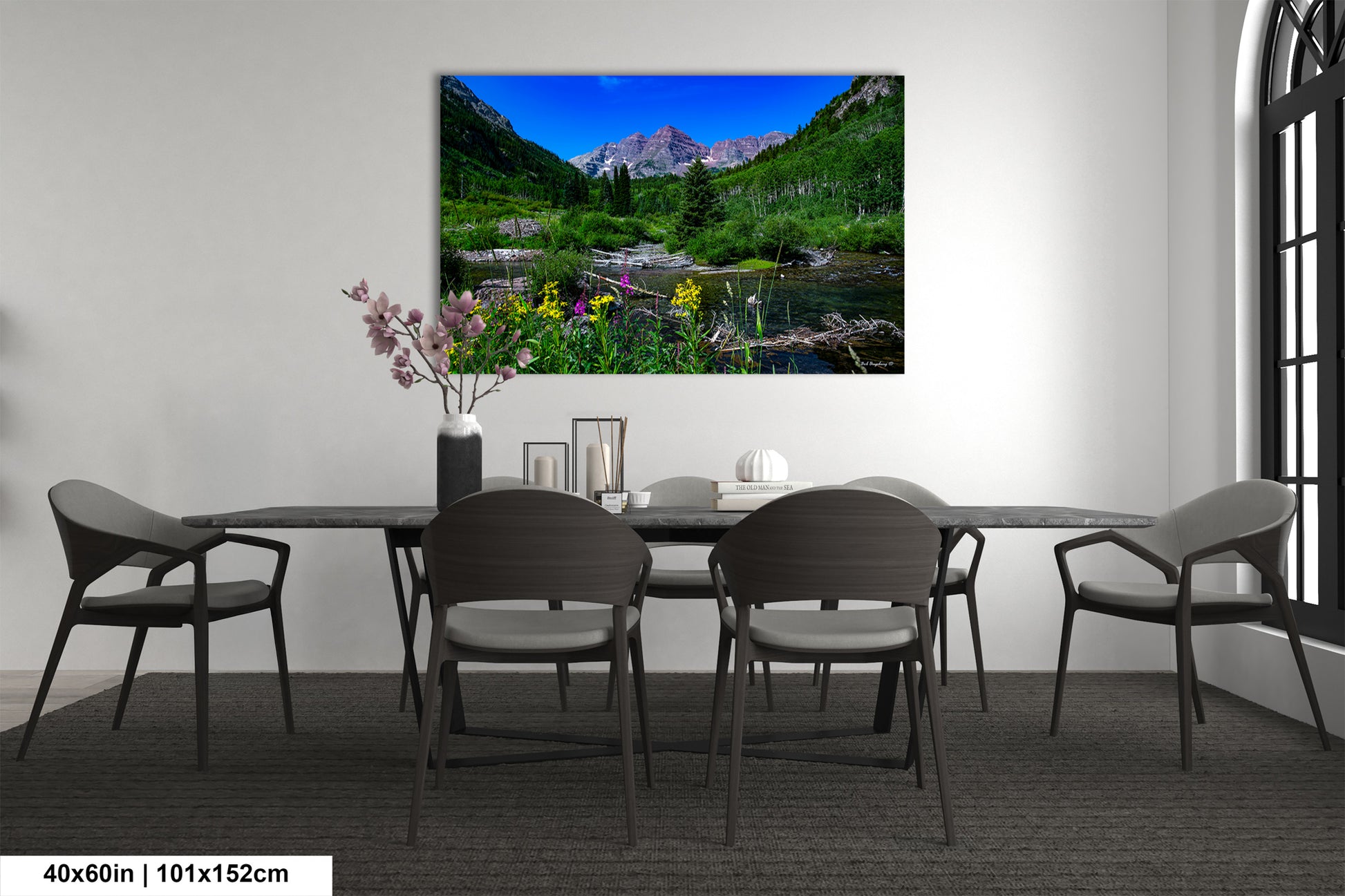 a room with a table and chairs and a painting on the wall