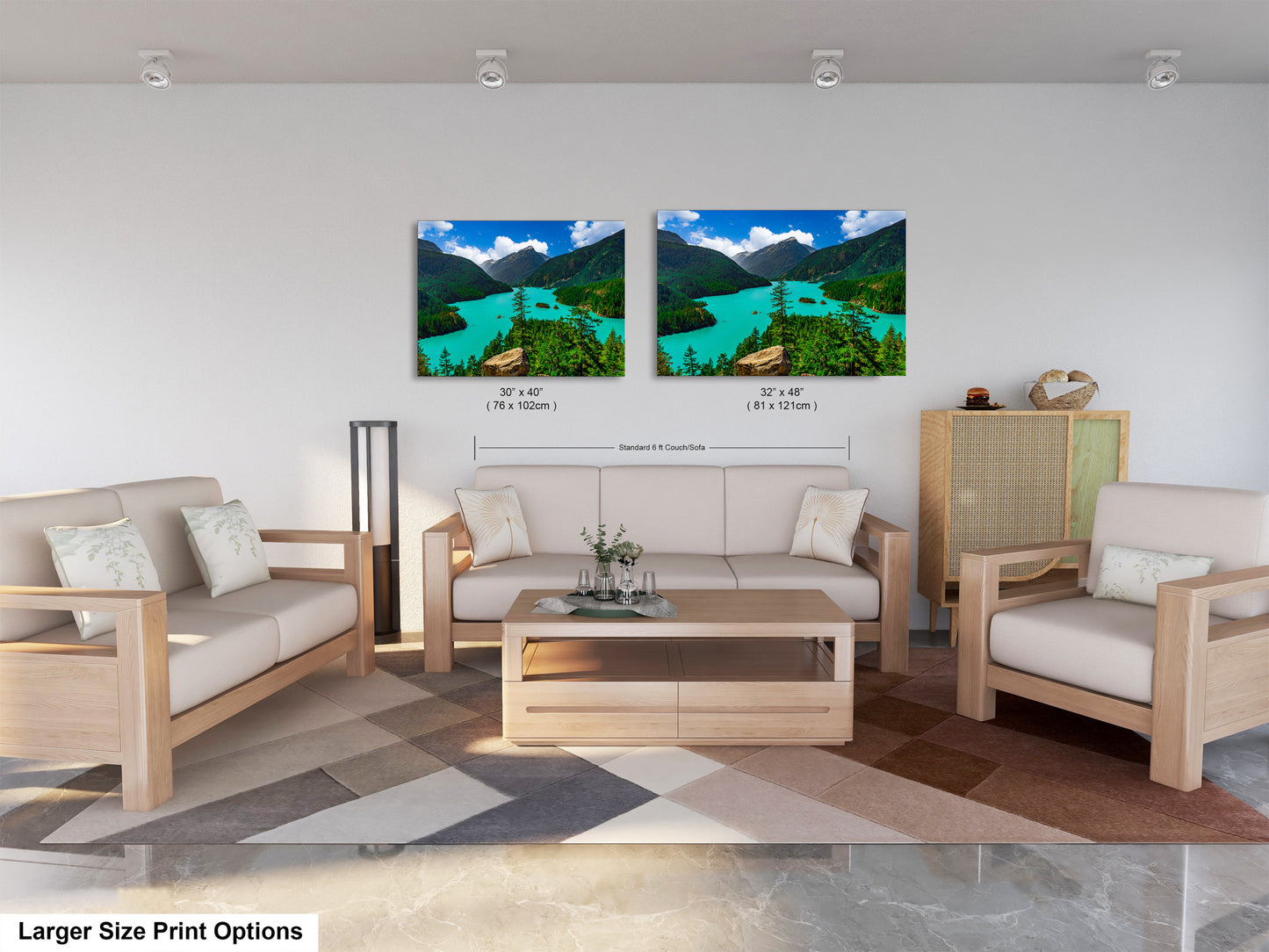 a modern living room with a large sofa, two chairs, and a coffee table. There are two framed landscape photographs hanging on the wall above the seating area, depicting a scenic mountain view.