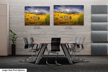 a dining room table with chairs in front of two pictures of mountains