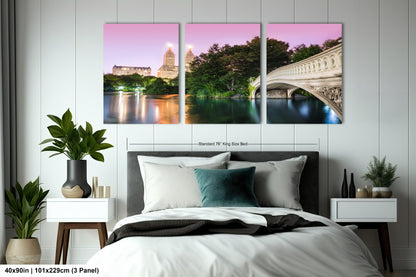 a bed with a white comforter and three paintings on the wall