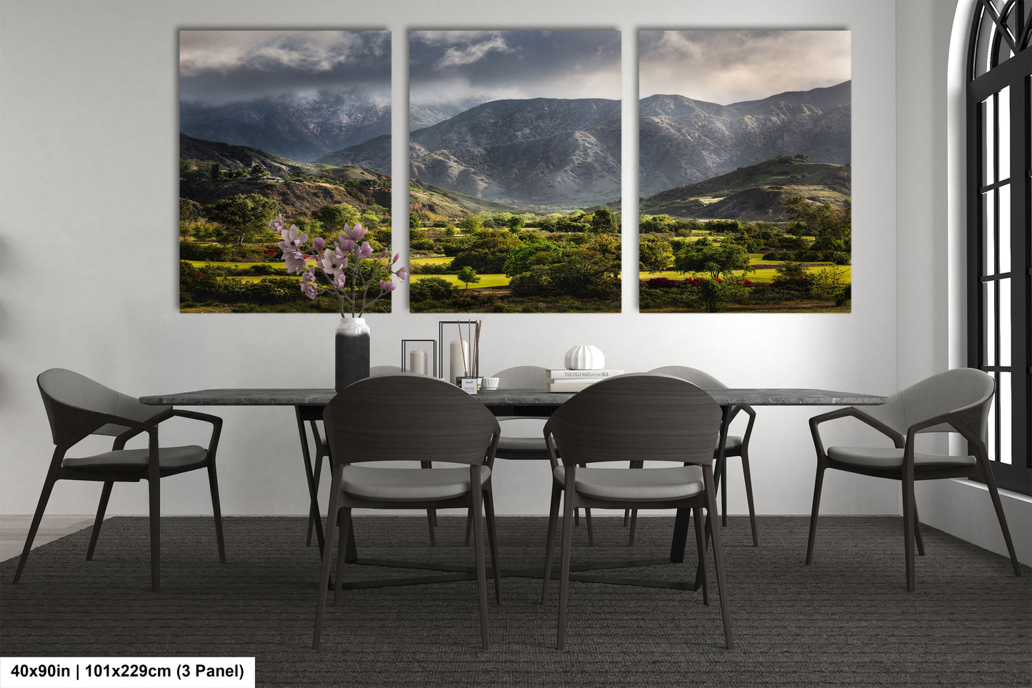 a dining room table with four chairs and a painting on the wall