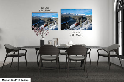 a modern dining room with a black table and chairs, and two framed landscape paintings hanging on the wall above the table.
