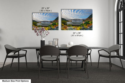 a dining table with four chairs and a vase with flowers