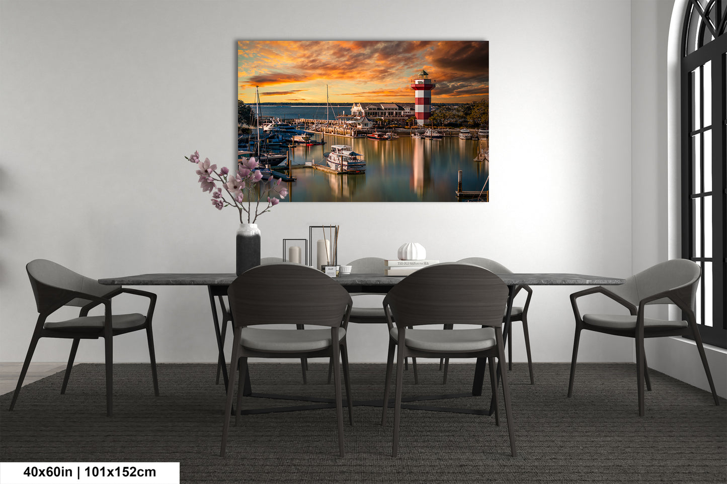 a dining room table with chairs and a painting on the wall