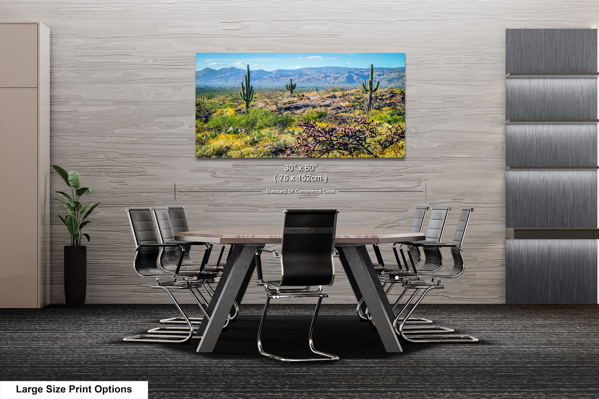 a modern office space with a large, framed landscape painting of a desert scene hanging on the wall above a wooden table surrounded by chairs.
