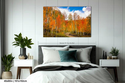 a bed room with a neatly made bed and a painting on the wall