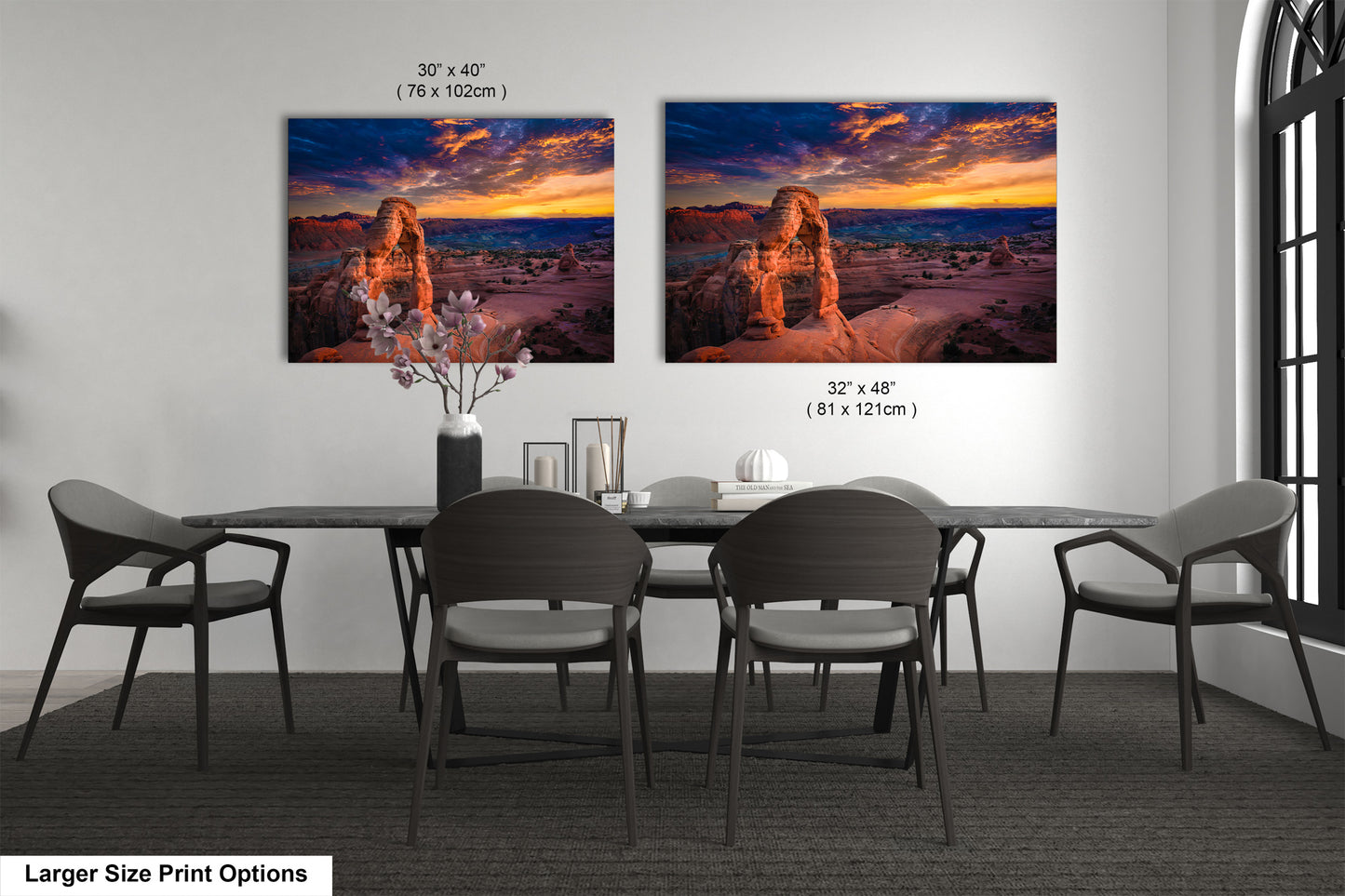 a dining room table with four chairs and two pictures on the wall