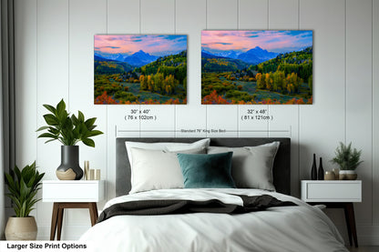 a bedroom with a bed and two pictures on the wall
