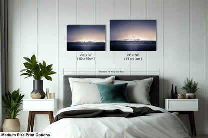 a bedroom with a bed and two pictures on the wall