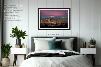 a bedroom with a bed and a picture hanging above it