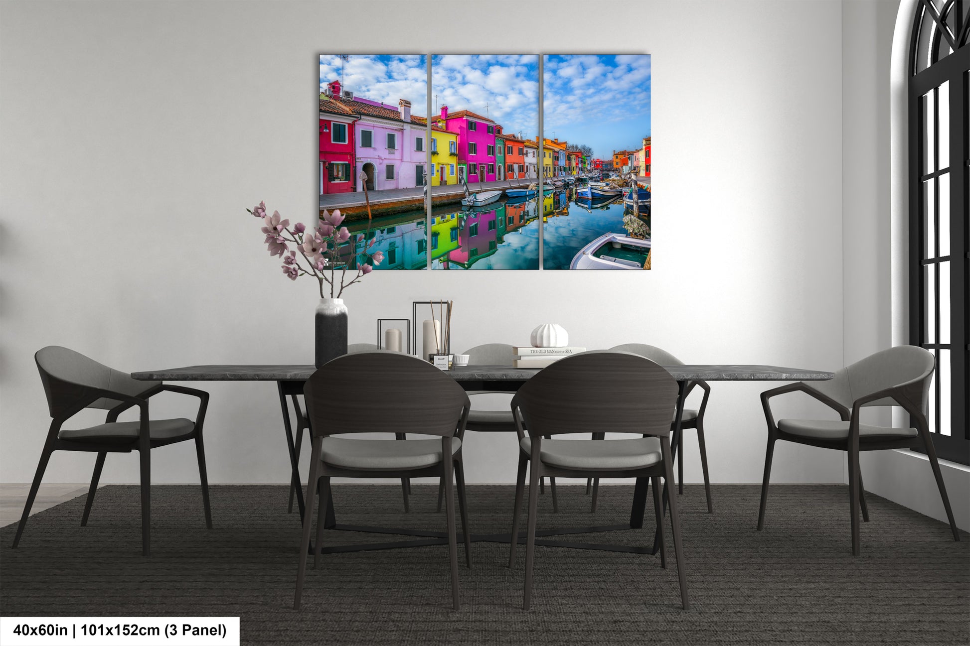 a dining room table with chairs and a painting on the wall