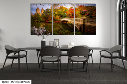 A modern dining room with a large wall-mounted painting depicting a scenic view of Central Park in New York City, featuring a bridge and autumn foliage.